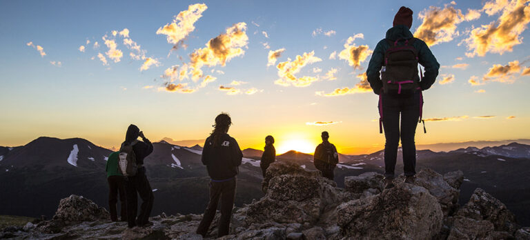 people outdoors at sunset