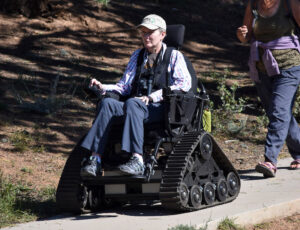 person in track chair in park